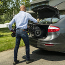 Man Loading The Feather Mobility Scooter Into The Trunk Of A Car In A Suburban Setting