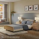 Side View Of The Accora Empresa 12-Function Hi Low Adjusting Nursing Bed Shown In Skandi Design With Oak Wood Finish In A Homecare Setting
