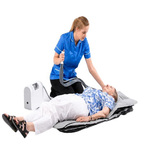 A Caregiver In A Blue Uniform Applies The Winncare Mangar Camel With Airflo 24 To An Elderly Woman
