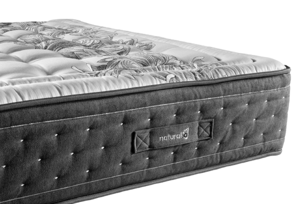 A Close-Up Studio Shot Of The Eurolux Multisens: The 11-Layer Luxury Mattress Crafted By Masters Mattress Corner Showing A Tufted Dark Gray Side Panel With A Visible 'Naturala' Label, And A Light Gray Quilted Top Surface With A Floral Pattern