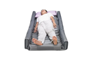 A Person Lying On Wellell Optima Turn Lateral Rotation Pressure Relief Mattress With Stretch Cover And A Light Purple Pillow Shown In The Left Rotation Position