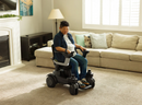 A Woman Smiling While Using The STRUTT ev1 Smart Electric Mobility Vehicle Shown In An Indoor Home Setting