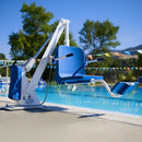 Aqua Creek Admiral Pool Lift Front View On A Pool Deck With Trees And Flags In The Background.
