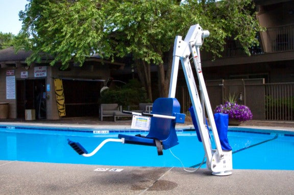 Aqua Creek Mighty 400 Pool Lift Blue And White Color Front View Next To A Swimming Pool With Trees And Building In The Background. 