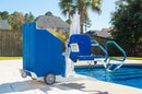 Aqua Creek Portable Pool Lift Blue And White Color With Steps On A Pool Deck, Surrounded By Trees And Houses. 