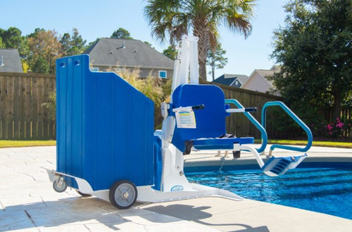 Aqua Creek Portable Pool Lift Blue And White Color With Steps On A Pool Deck, Surrounded By Trees And Houses.