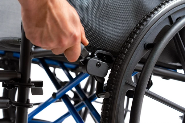 Close Up View Of A Hand Adjusting The Wheel Lock Mechanism Of The Strongback ErgoSteel Wheelchair