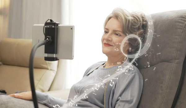 Close Up View Of An Elderly Woman Using The Tablet Attachment To Listen To Music While Sitting On The StarSleep Starise Massage Lift Chair Shown With Music Notes