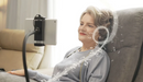 Close Up View Of An Elderly Woman Using The Tablet Attachment To Listen To Music While Sitting On The StarSleep Starise Massage Lift Chair Shown With Music Notes