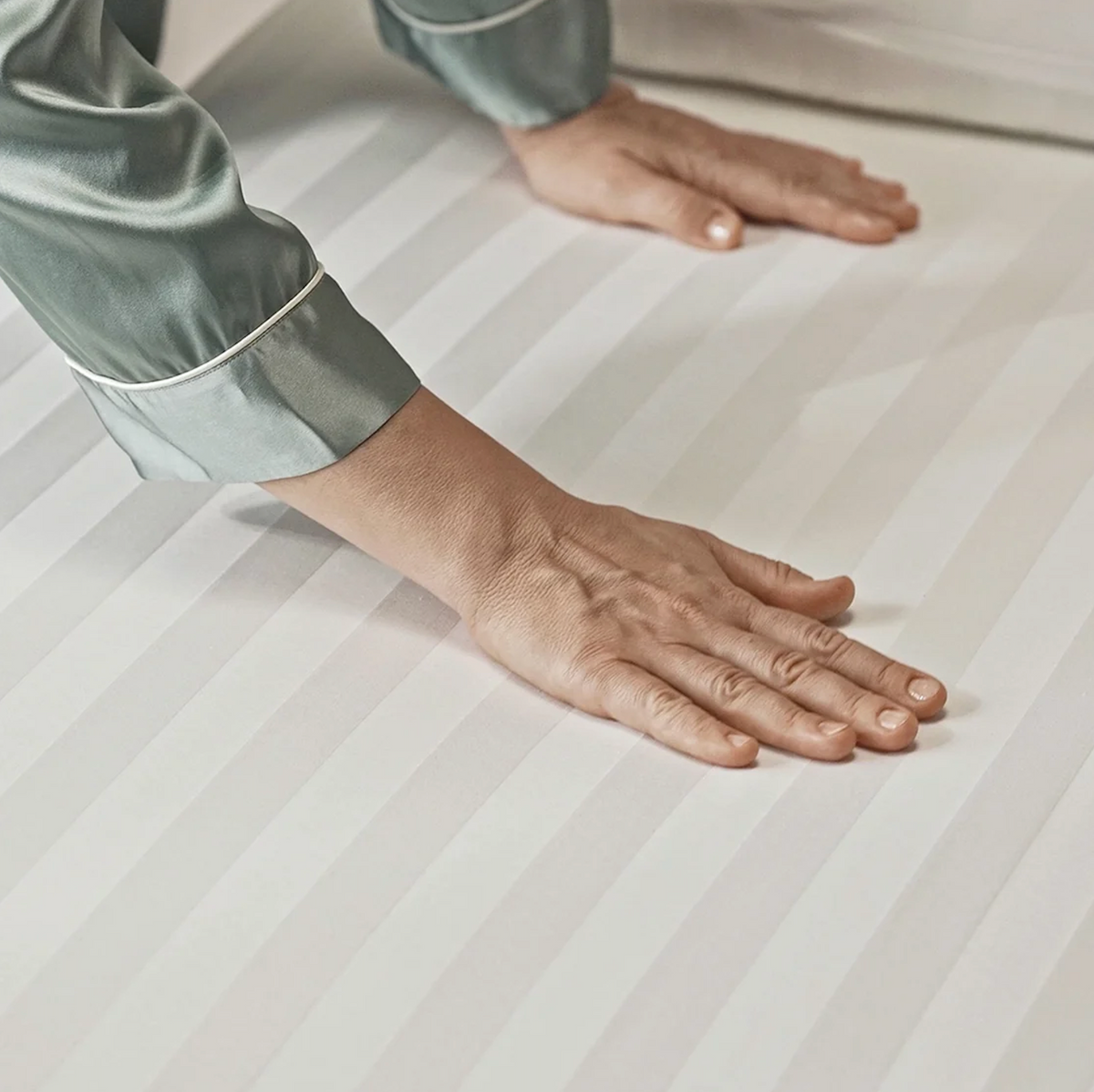 Close Up View Of Hands Adjusting The StarSleep Arlo Rotating Bed Sheet Set