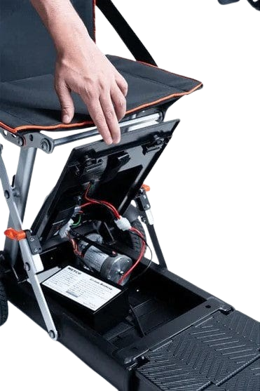 Close Up View Of The Battery Compartment For The Feather 27X Mobility Scooter Shown With A Hand Lifting The Lid