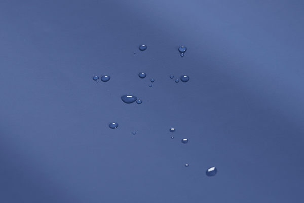 Close Up View Of The Cover Of The Wellell Domus 3 Alternating Pressure Redistribution Mattress System With Quilted Cover Shown With Water Droplets Highlighting Its Waterproof Material