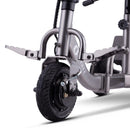 Close Up View Of The Front Wheel And Footrests For The Reyhee Triad Compact Folding Electric Mobility Scooter Shown With The Gun Metal Colored Frame