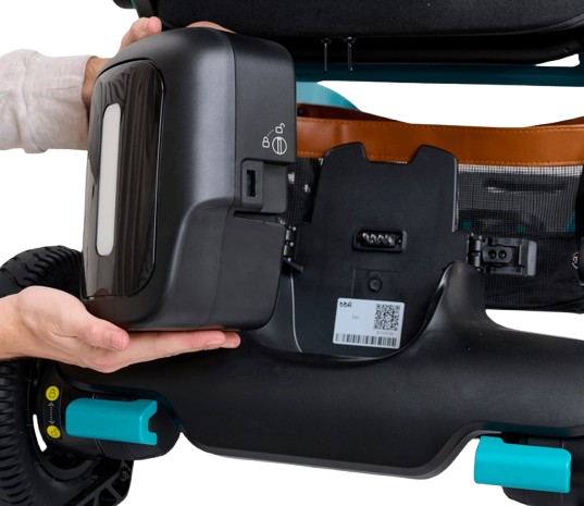 Close Up View Of The Golden Technologies Ally Pro Omnidirectional Electric Wheelchair Off Board Battery Shown With Hands Holding The Battery