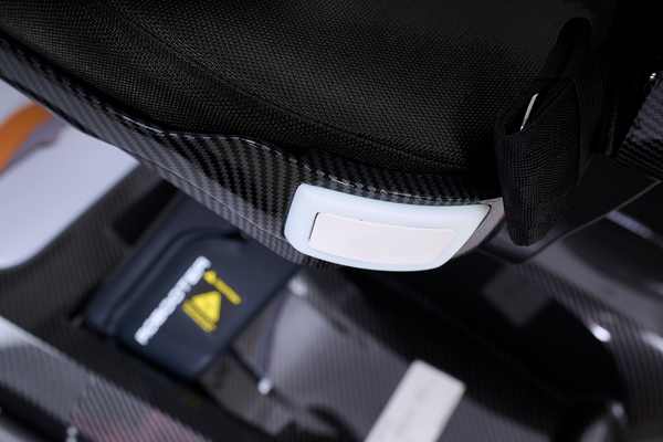 Close Up View Of The Golden Technologies Ally Sport Omnidirectional Electric Wheelchair Seat Fabric And Light Shown In Carbon Fiber Color