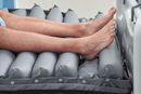 Close Up View Of The Inflated Cells For The Wellell Domus Auto Pressure Redistribution Mattress System with Quilted Cover Shown With Patient's Feet Lying On The Mattress