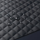 Close Up View Of The Paiseec Q5 Carbon Fiber Electric Wheelchair Black Quilted Fabric With Water Droplets Demonstrating Water Resistance