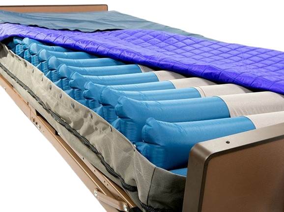 Close Up View Of The Proactive Medical Protekt Aire 9900 Low Air Loss/Alternating Mattress System Shown With The Top Cover Removed, Revealing Multiple Blue Air Chambers And A Gray Fabric Liner, With A Purple Quilted Mattress Topper