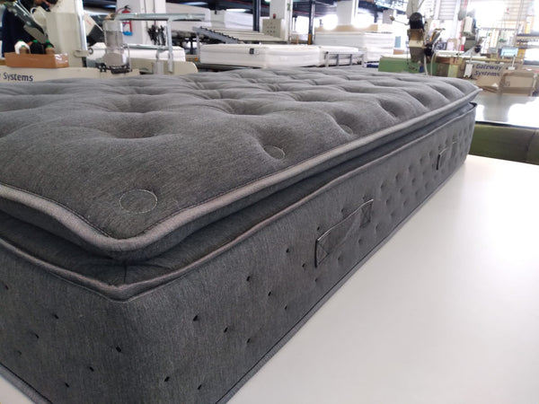 Close Up View Of The Side Of The Eurolux Novis: The 5-Layer Luxury Mattress Crafted By Masters Shown In A Factory Setting