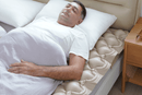 Close Up View Of The Wellell Domus 1 Alternating Pressure Redistribution Mattress Shown With A Patient Lying On The Mattress In A Home Care Setting