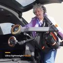 Close Up View Of Elderly Woman Loading The Paiseec W1 Lightweight 2‑in‑1 Electric Wheelchair Shown In Orange Color Into The Trunk Of Her Car