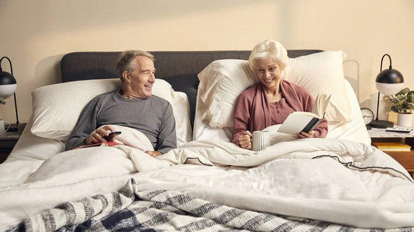 Front Centered View Of Elderly Couple Sitting Up On An Adjustable Bed With The Luxury Dawn House Foam Mattress