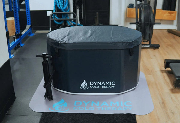 Front Centered View Of The Dynamic Oval Inflatable Cold Plunge Shown With Cover In A Gym Setting