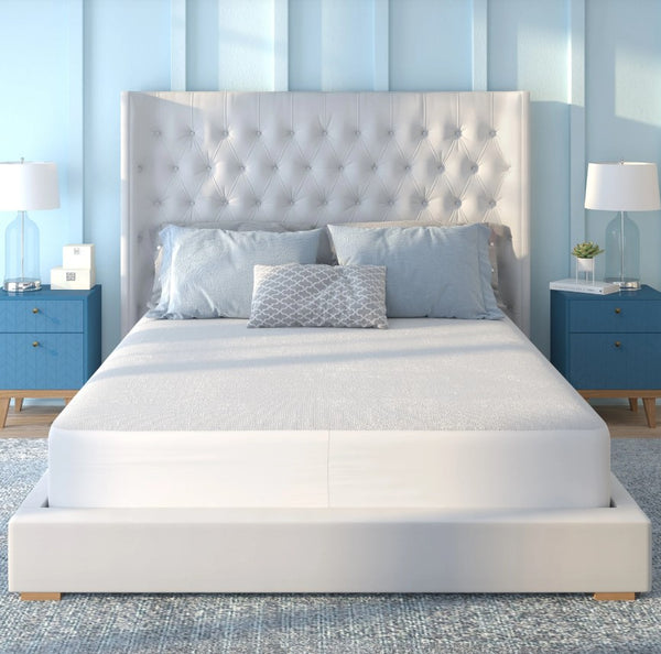 Front Centered View Of The Rize Home Ultra-Soft Mattress Protector On A White Bed With Tufted Headboard In A Bedroom With Blue Walls And Furniture 
