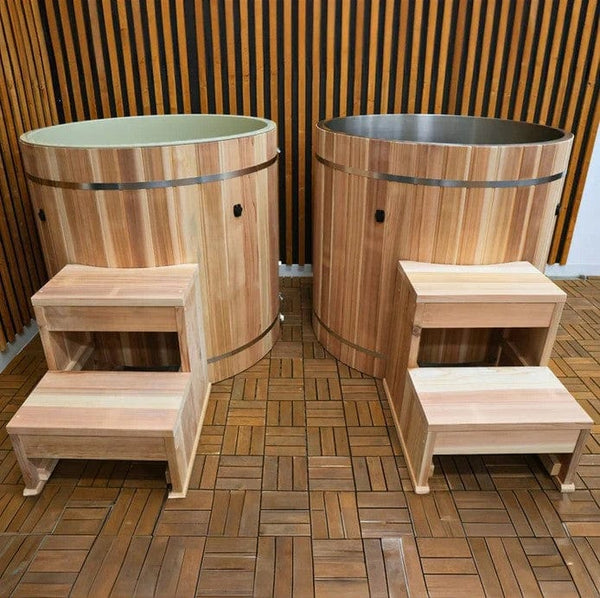 Front Centered View Of Two Of The Dynamic Cedar Cold Plunge Barrels Shown With Steps And Stainless Steel And Plastic Interior Material In An Outdoor Setting