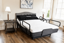 Front Left Side View Of The Flexabed Hi Low Adjustable Bed Shown With Four Side Rails And A Mattress In An Indoor Setting During The Day