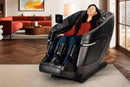 Front Left Side View Of The Kyota Zenyu M338 Massage Chair Shown In An Indoor Setting With A Woman Sitting In The Chair