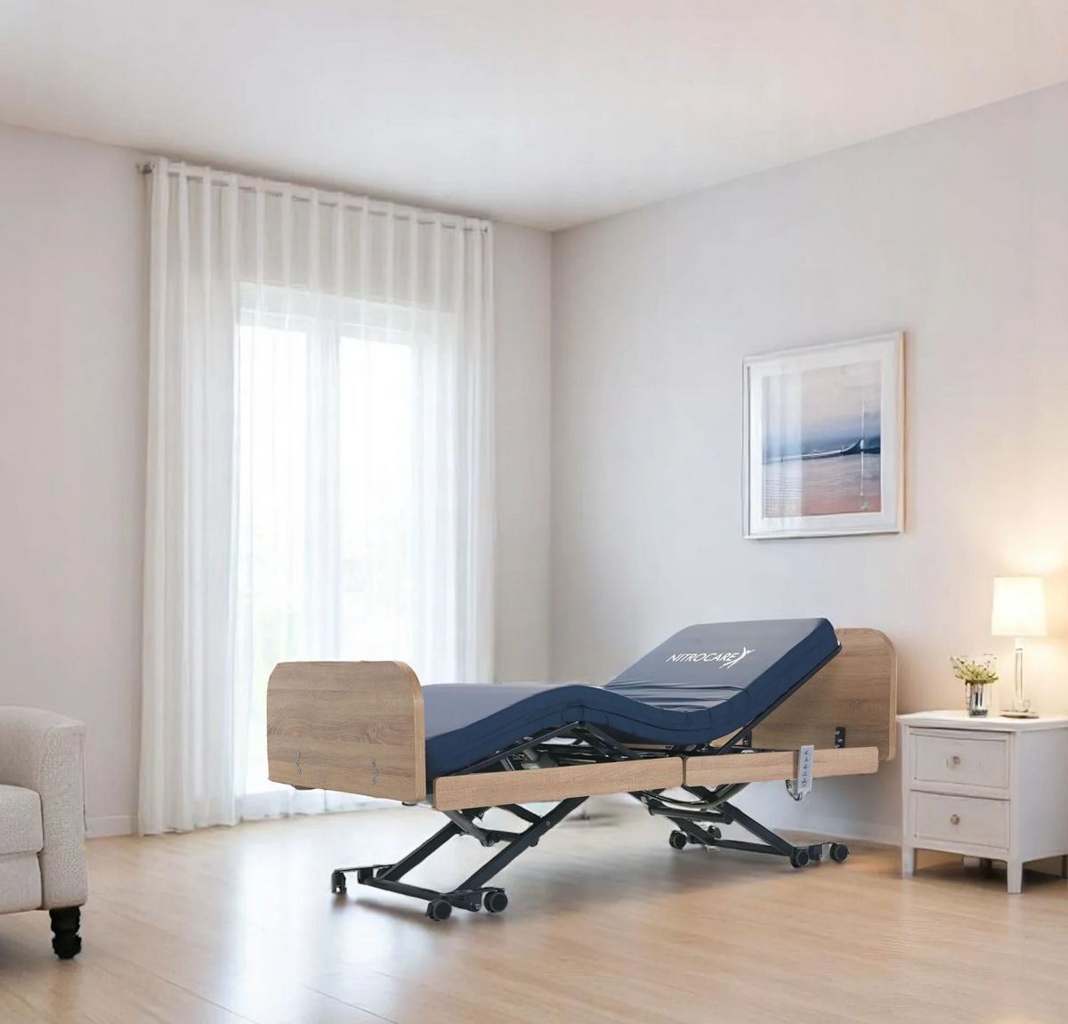 Front Left Side View Of The Nitrocare Miranda 7410 Hi Low Adjustable Bed In The Raised Position With The Leg And Head Portion In The Articulated Position Shown In A Homecare Setting