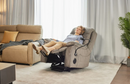 Front Left Side View Of The StarSleep Starise Massage Lift Chair With An Elderly Woman Relaxing In The Reclined Position Shown In An Indoor Living Room Setting