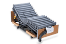 Front Left Side View Of The Wellell Domus 3 Alternating Pressure Redistribution Mattress System With Quilted Cover Shown On An Adjustable Bed With The Control Unit Hanging On The Footboard Without The Cover