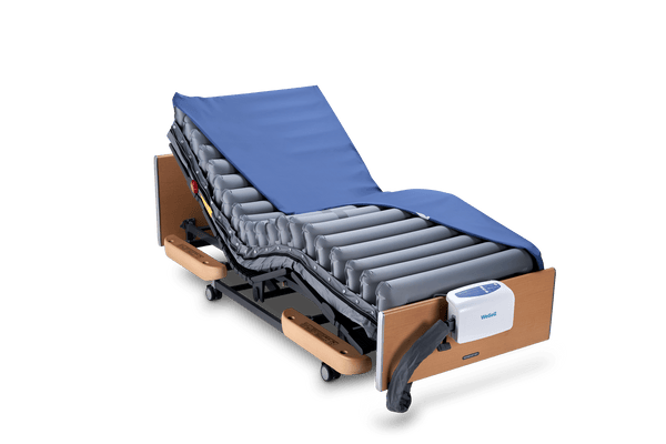 Front Left Side View Of The Wellell Domus Auto Pressure Redistribution Mattress System With Quilted Cover Shown On An Adjustable Hospital Bed In The Upright Position
