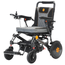 Front Left View Of The Bangeran Pegasus Kids Pediatric Electric Wheelchair Shown In Black And Orange Color