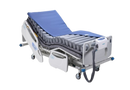 Front Right Side View Of An Adjustable Hospital Bed With The Wellell Domus Auto: Automatic Pressure Redistribution Mattress System On It With The Control Unit Hanging On The Footboard