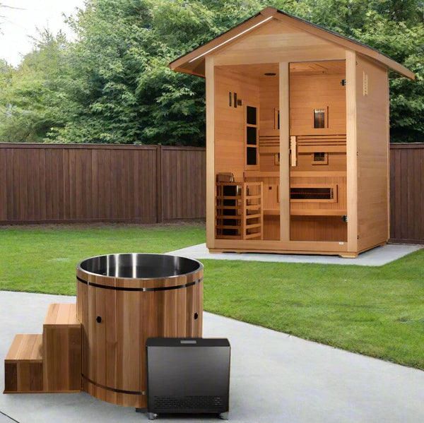 Front Right Side View Of The Dynamic Cedar Cold Plunge Barrel Shown With Steps, Stainless Steel Interior Material, And Chiller With A Sauna In The Background In An Outdoor Setting