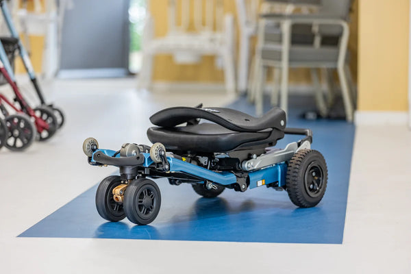 Front Right Side View Of The FreeRiderUSA Luggie Super Plus 3 Folding Mobility Scooter Shown In The Folded Position In The Ocean Blue Color In An Indoor Setting