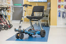 Front Right Side View Of The FreeRiderUSA Luggie Super Plus 3 Folding Mobility Scooter Shown In The Ocean Blue Color In An Indoor Setting