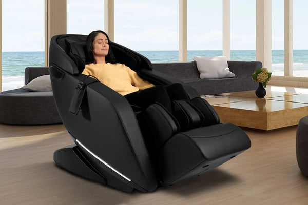 Front Right Side View Of The Kyota Genki M380 Massage Chair In Black Color Shown In An Indoor Setting With A Woman Sitting In The Chair