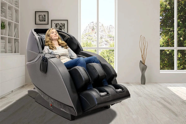 Front Right Side View Of The Kyota Kansha M878 Massage Chair In Black And Gray Color In An Indoor Setting With A Woman Sitting In The Chair