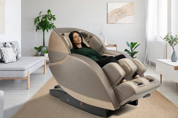 Front Right Side View Of The Kyota Kansha M878 Massage Chair In Gold And Tan Color In An Indoor Setting With A Woman Sitting In The Chair