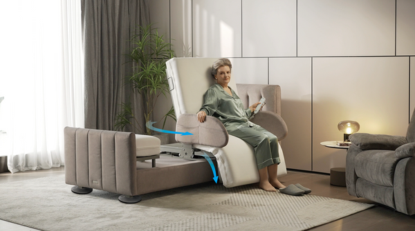 Front Right Side View Of The StarSleep Arlo Rotating Bed Shown In The Chair Position In A Bedroom Setting With An Elderly Woman Sitting In The Bed With Blue Arrows Indicating The Beds Movement