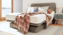 Front Right Side View Of The The Dawn House Hi Low Adjustable Bed Shown In The Gray Slate Color With Headboard In A Bedroom Setting During The Day With Pillows And A Blanket Draped Over The Top Of The Bed