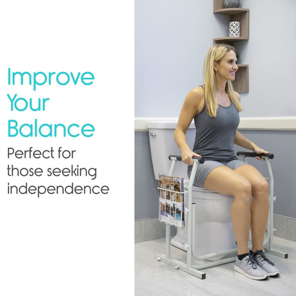 Front Right Side View Of The Vive Health Stand Alone Toilet Rail Placed Next To A Toilet Bowl With A Woman Using The Railing For Balance Assistance In A Bathroom Setting Demonstrating Its Stabilizing Support