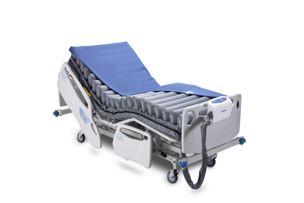 Front Right Side View Of The Wellell Domus Auto Pressure Redistribution Mattress System with Quilted Cover Shown On An Adjustable Hospital Bed In The Upright Position With Cover Slightly Removed