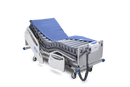 Front Right Side View Of The Wellell Domus Auto Pressure Redistribution Mattress System with Quilted Cover Shown On An Adjustable Hospital Bed In The Upright Position With Cover Slightly Removed
