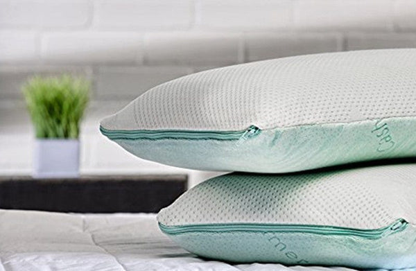 Front View Of Two Eurolux Green Planet Pillows Stacked On Each Other Lying On A Mattress Shown In An Indoor Setting