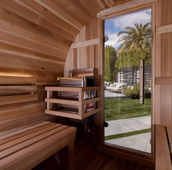 Inside View Of The Golden Designs Zurich 4-Person Barrel Sauna | GDI-B024-01 Showing The Front Door And The Heater With A Palm Tree In The Background
